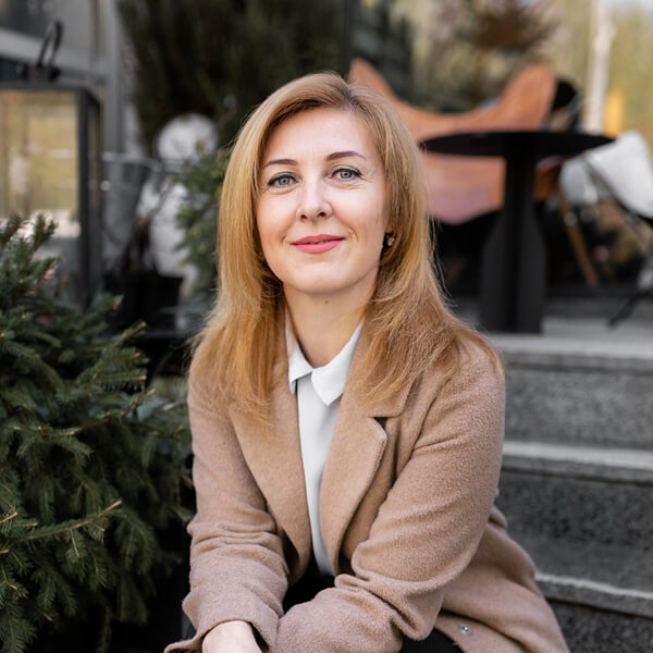 Angéla Molnár, adminisztrációs és pénzügyi menedzser portréja, mosolygós nő szabadban, világos kabátban